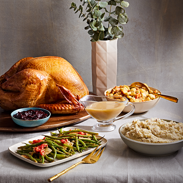 Full turkey dinner on a grey background.